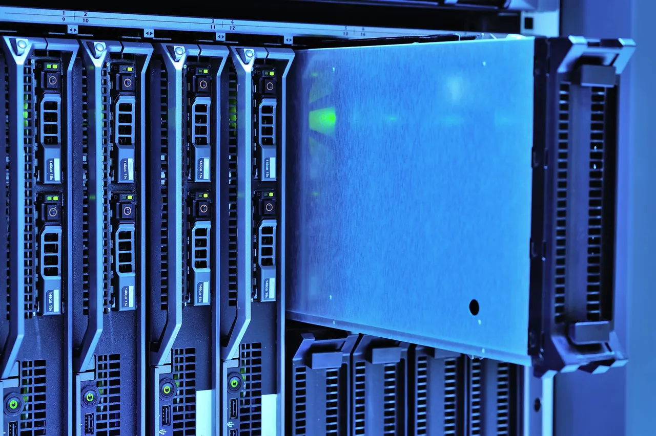 A row of blade servers lit blue, a chassis handle in the foreground