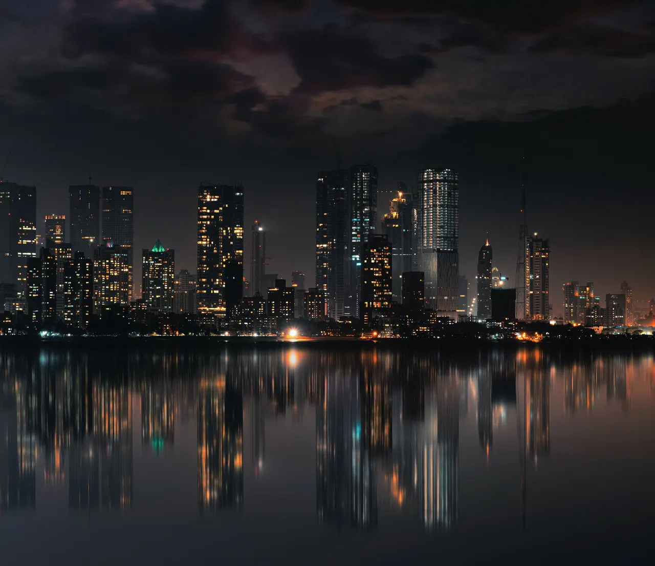 Les tours de Mumbai la nuit, illuminées et reflétées dans l’eau calme de la baie, Inde